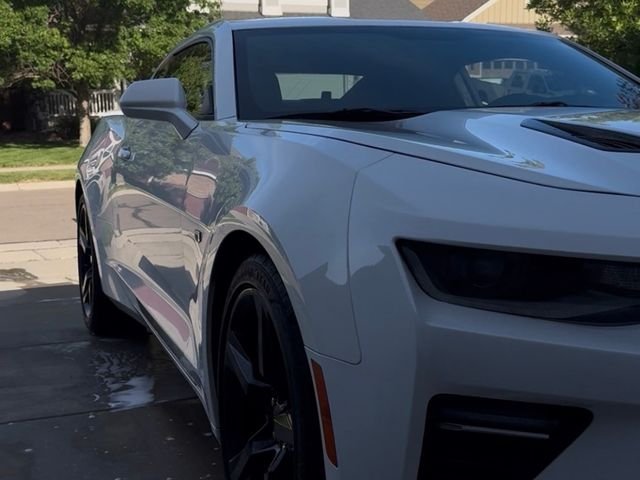 White Chevrolet Camaro gleaming in a driveway after a hand wash