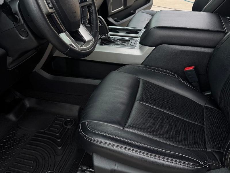 After: the same Ford pickup interior detailed, with a clean floor mat, console and black leather seat