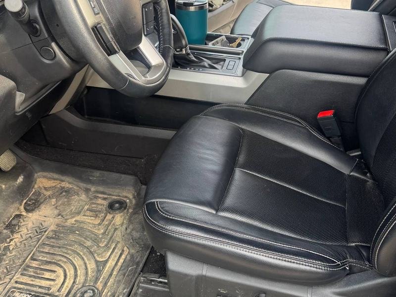 Before: a Ford pickup interior with a dusty, dirt-covered floor mat and cluttered console