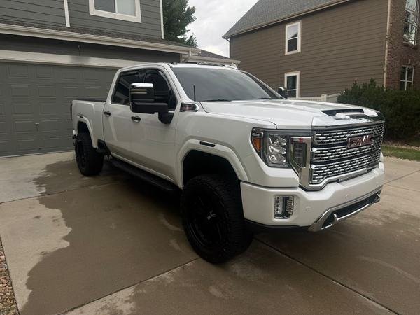 White GMC pickup gleaming in a driveway after an exterior wash